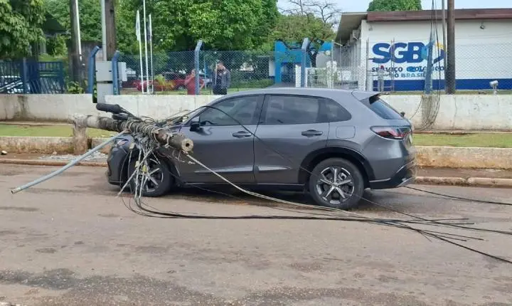 Poste cai sobre carro depois de carreta puxar fiação na Avenida Lauro Sodré em Porto Velho